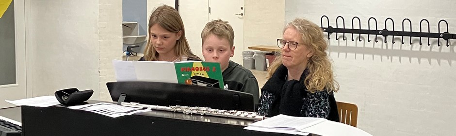 2 elever spiller klaver med underviser